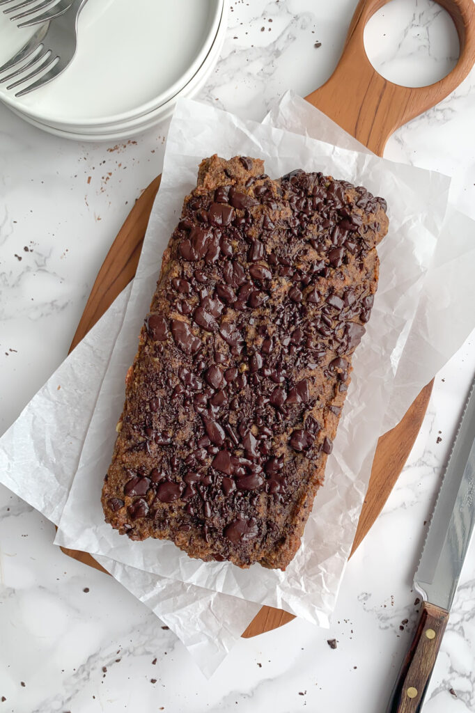 chocolate pumpkin quick bread on a cutting board, waiting to be sliced and served