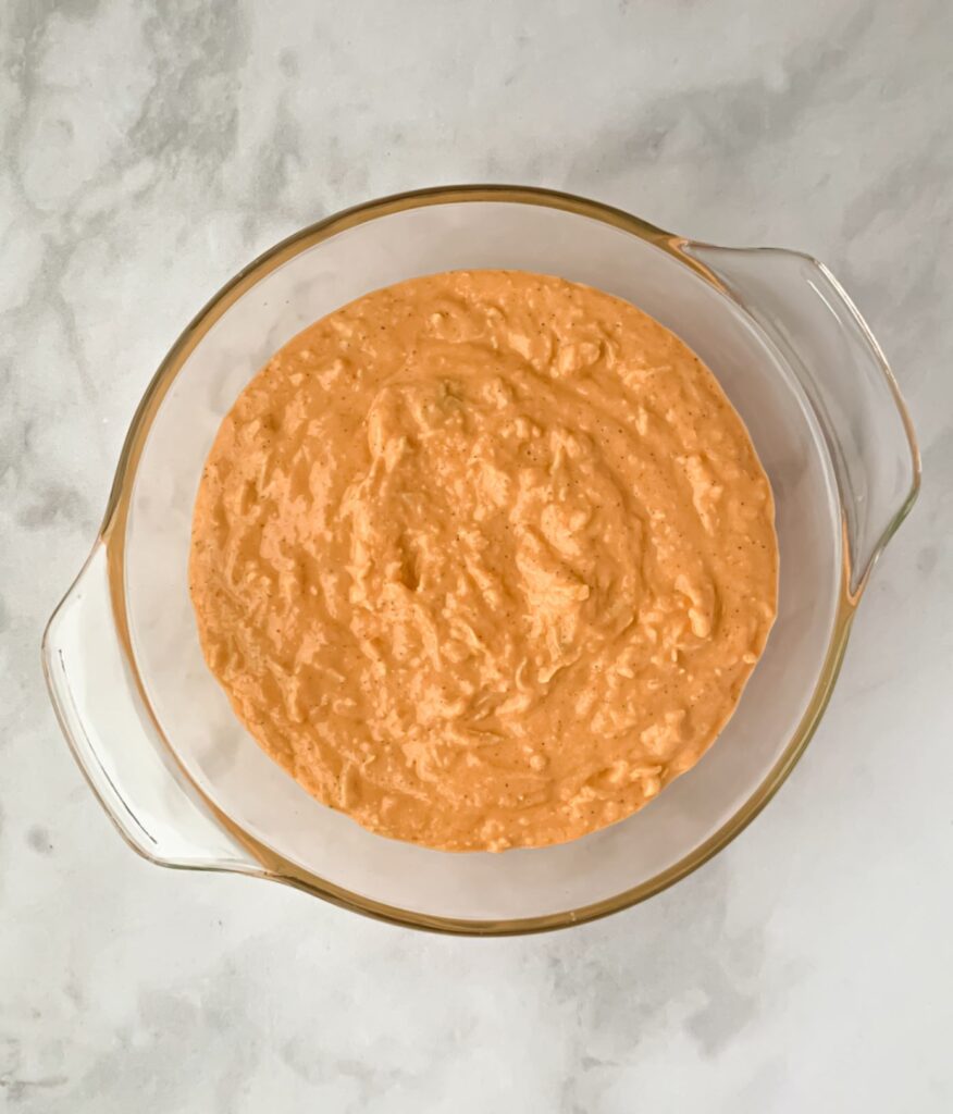 dairy free buffalo chicken dip in a glass baking dish before being baked 