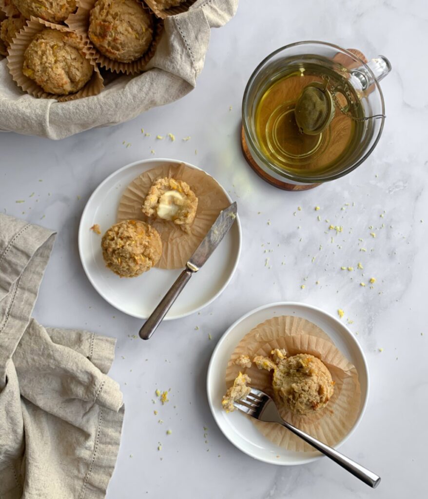 muffins in a bowl and on two plates served with chamomile tea.