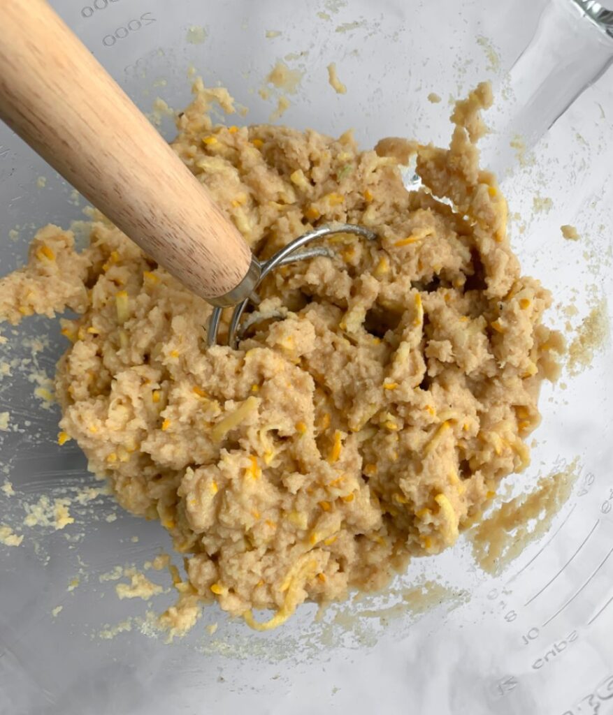 thick and sticky muffin batter in a bowl with a danish whisk