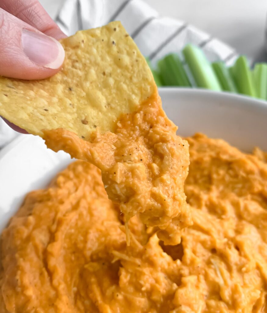 corn chip being dipped into the dip