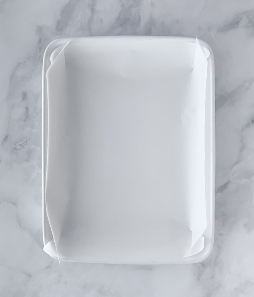 white ceramic baking dish lined with parchment paper