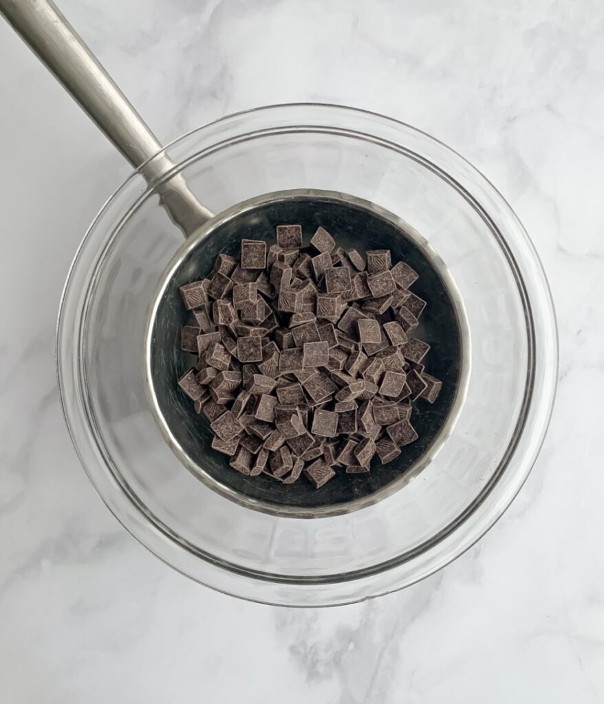 chunks of chocolate in a glass bowl on a pot of water