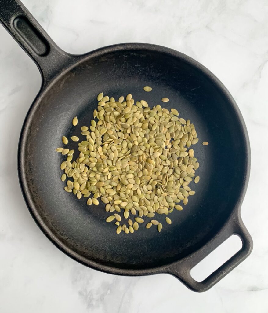 toasting pumpkin seeds in a cast iron skillet