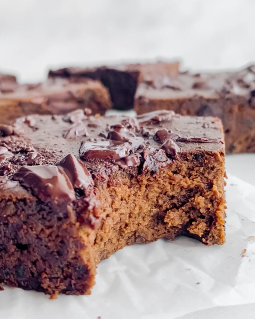 fudgy brownie up close with bite taken from it.