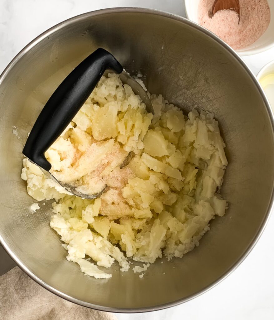 potatoes in a bowl being mashed