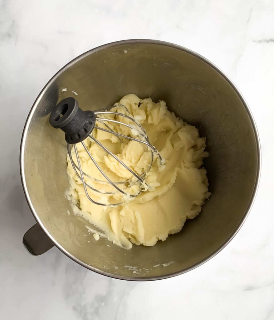 mashed potatoes in a stand-mixer bowl with a whisk attachment