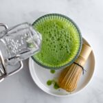 sparkling water being poured into a glass with matcha.