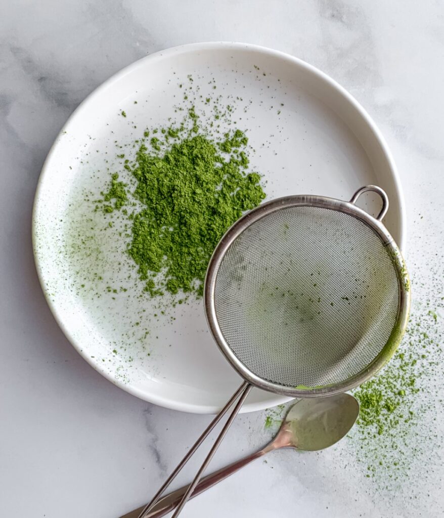 matcha powder on plate with small sifter and spoon.