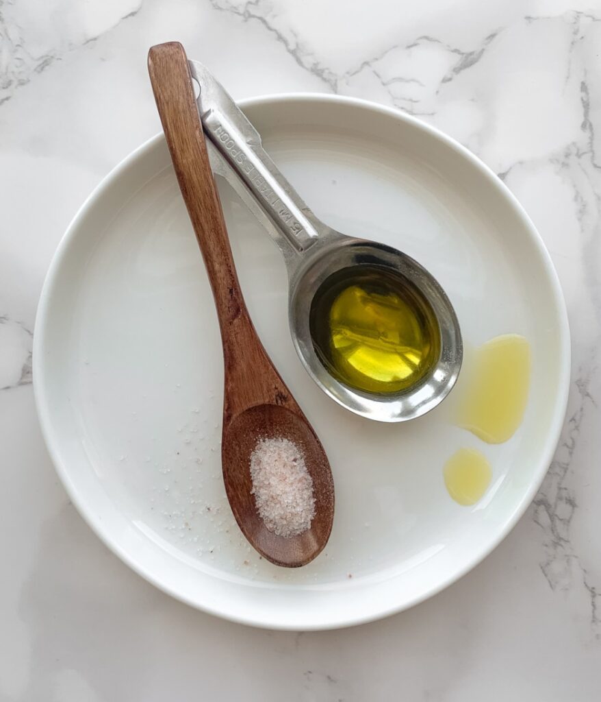 spoons on a white plate, each with olive oil and salt