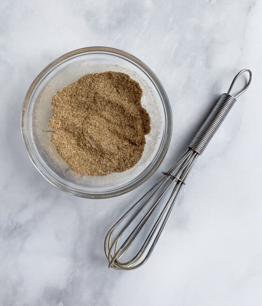 mixed up spices in a small bowl with a tiny whisk