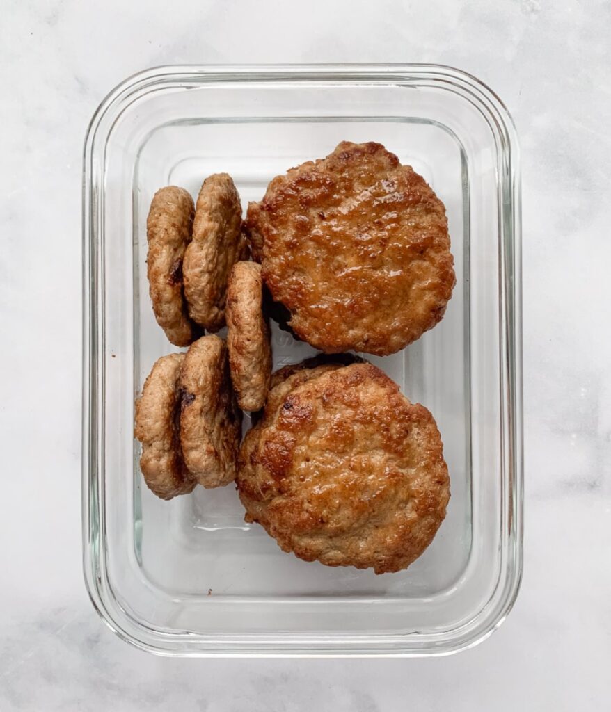 cooked chicken breakfast sausage patties in a glass storage container