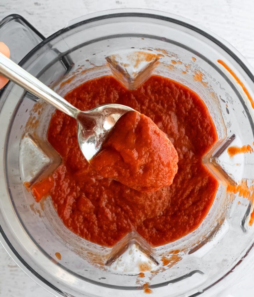 close up of uncooked ketchup on spoon coming out of a blender