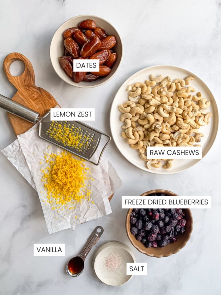 Ingredients for homemade blueberry energy balls including dates, cashews, freeze-dried blueberries and lemon zest