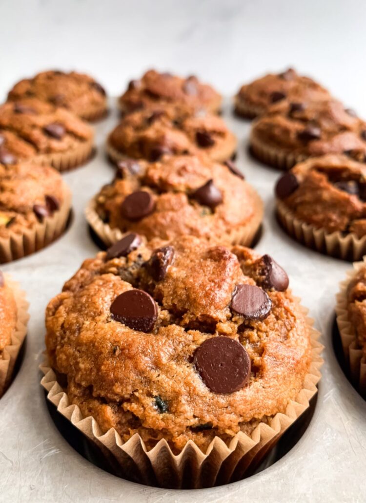 close up of healthy chocolate chip zucchini muffins cooling in the muffin tin after baking.