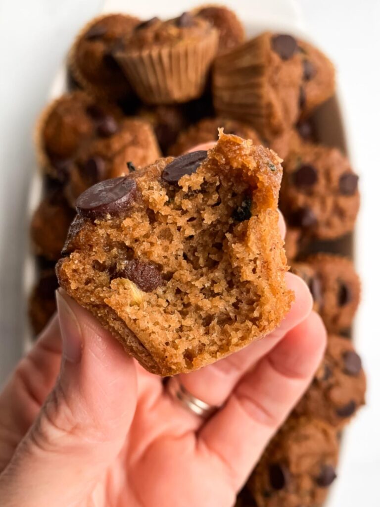 close up of a moist gluten-free banana zucchini mini muffin showing the soft texture inside.