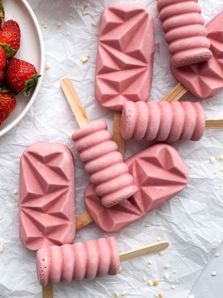 Strawberry yogurt popsicles that provide protein and fruit in a kid-friendly frozen snack.