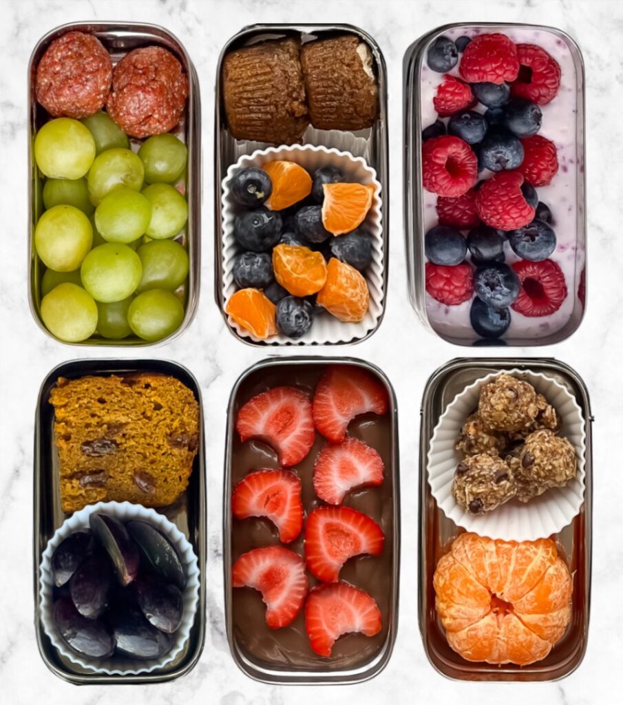 Examples of healthy snack combinations for kids that combine protein, fibre, healthy fats, and carbohydrates -- 6 snacks shown in rectangular metal containers.
