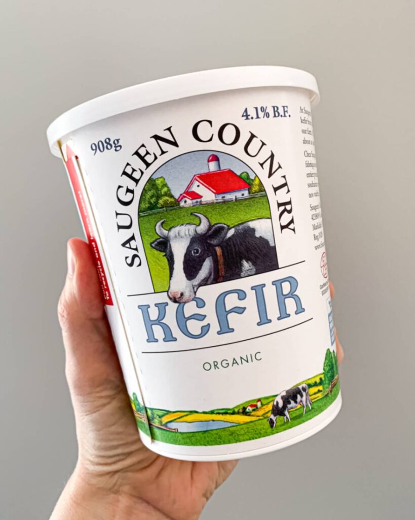 hand holding up a container of saugeen country kefir yogurt